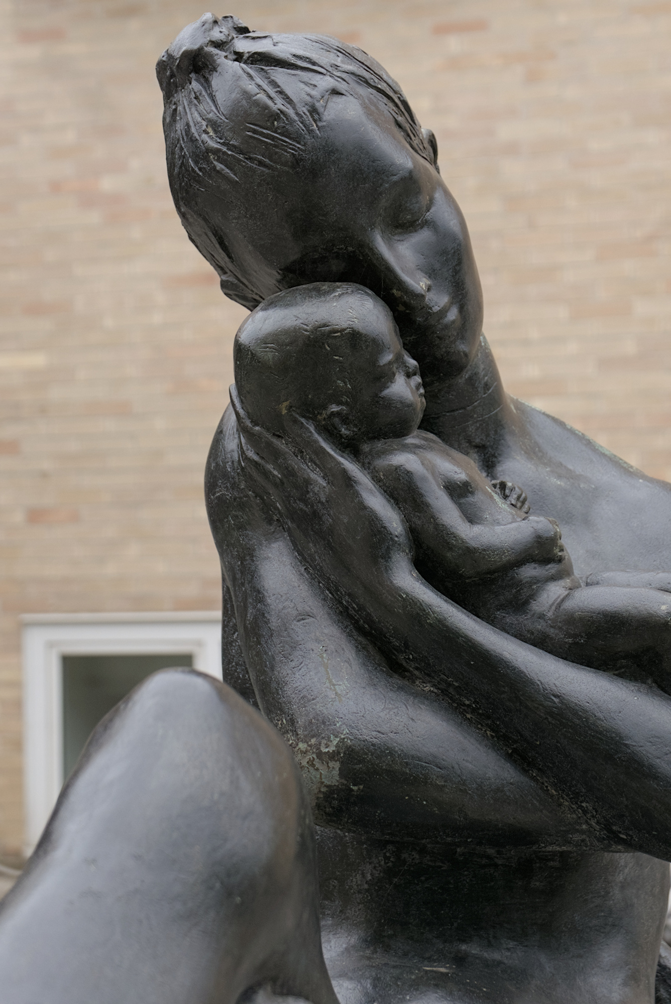 Amleto Sartori, *Maternità*, tuttotondo in bronzo, 1958, presso l’ingresso alla clinica ostetrico-ginecologica (Giulio Brunetta con Daniele Calabi, 1953-56). Un intervento incauto ha rivestito il bronzo naturale di una patina nerastra. Via Nicolò Giustiniani 3, Padova