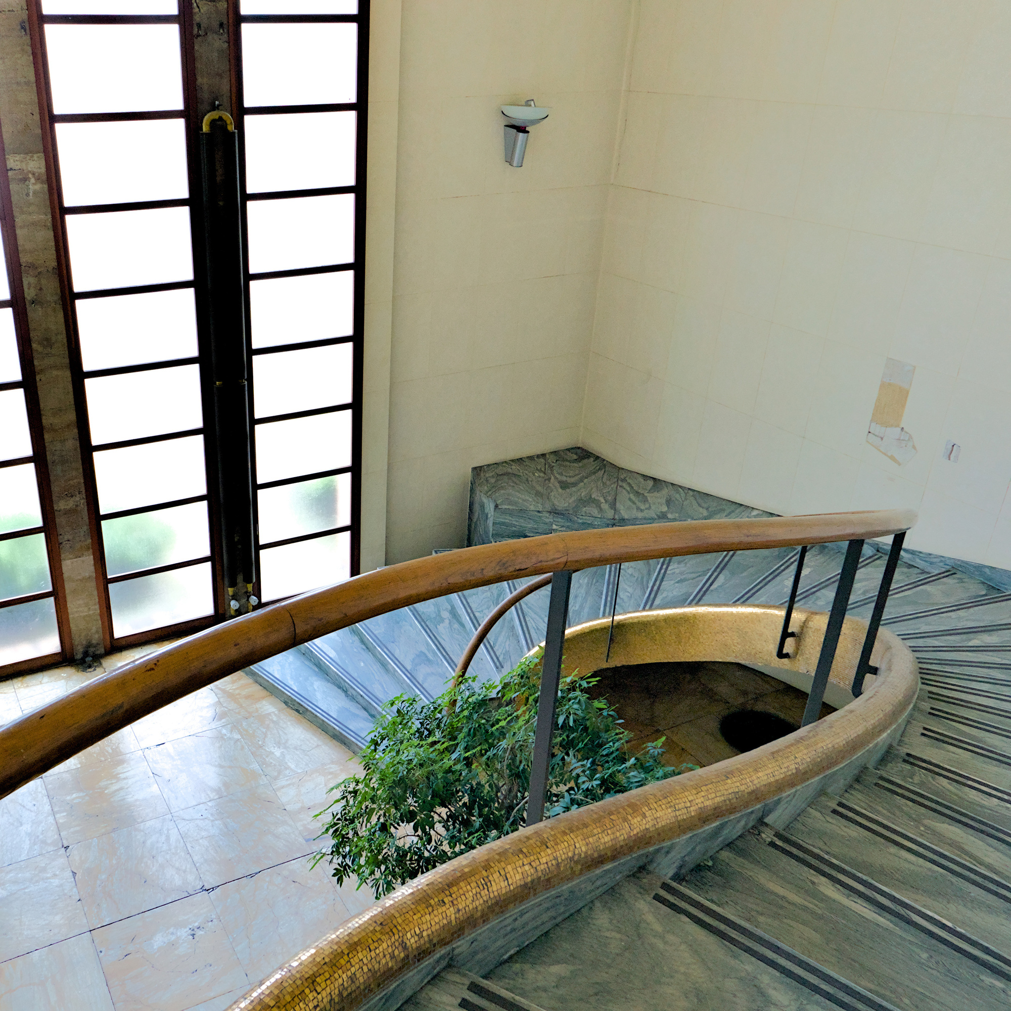 Atrio d'ingresso dell'ex Gruppo Rionale Fascista Bonservizi (Quirino De Giorgio, 1937-38) con scala in cipollino e cordone del bordo scale in mosaico d’oro. Le pareti erano rivestite da un grande ciclo di rappresentazioni allegoriche fasciste di Amleto Sartori su lastre di pietra di Nanto, occultate nel dopoguerra da uno strato di intonaco (e in tal modo salvate) da Giulio Brunetta. Nella parete a destra nella foto è visibile un'apertura servita a sondare in tempi recenti l'opera ora nascosta. Via Giordano Bruno 27, Padova