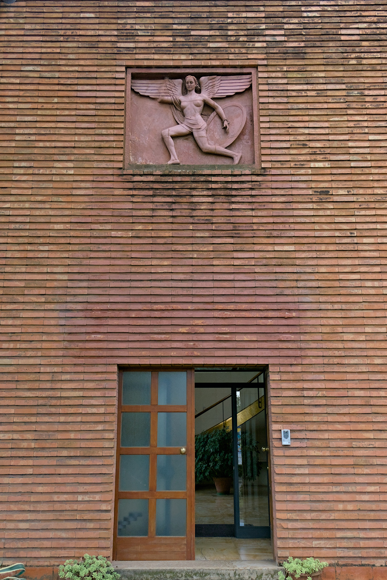 Esterno dell'ex Gruppo Rionale Fascista Bonservizi (Quirino De Giorgio, 1937-38). Sopra la porta d'entrata *Vittoria Fascista*, bassorilievo in cotto di Enrico Parnigotto, 1938. Via Giordano Bruno 27, Padova