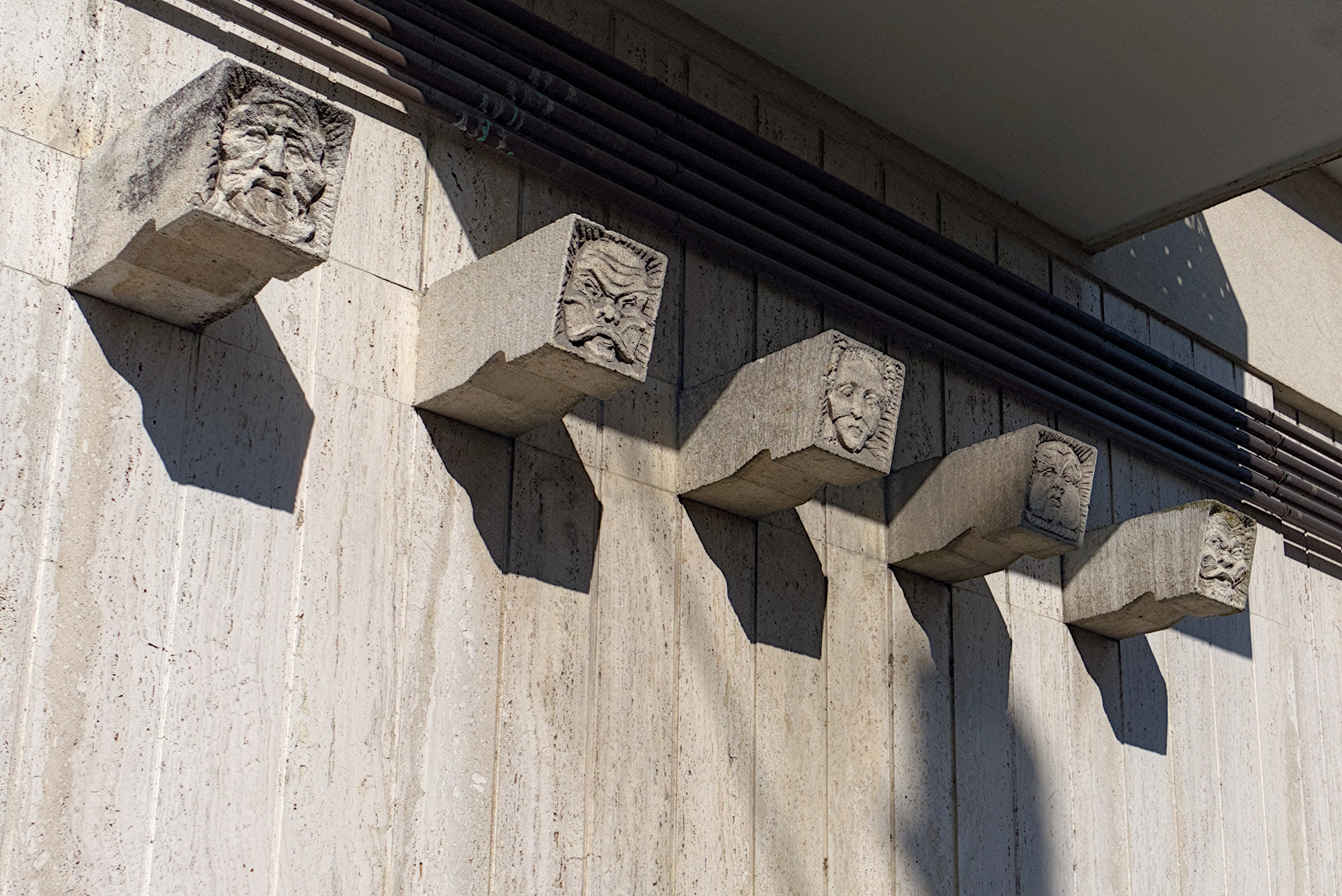 Amleto Sartori (attrib.), maschere in pietra a mo’ di antefisse all'esterno di condominio (Giovanni Zabai, 1954-56), angolo tra vicolo Nervesa della Battaglia e via Sorio, Padova