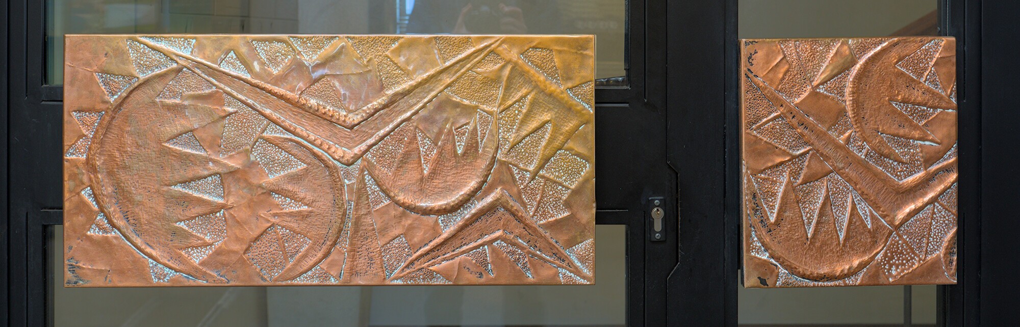 Autore non identificato, maniglioni in rame sbalzato, condominio, galleria Eremitani 4, Padova